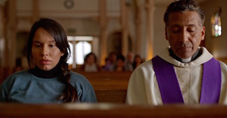 ​Actress, Valeria Chavez (Ceci), in confession next to actor, Tony Sagastizado (Father Sanchez) in Melissa Perez’s new film Still Devout.