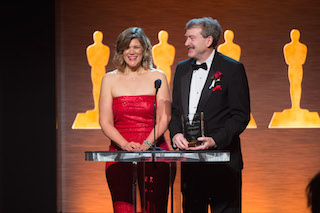 Robert Seidel, SMPTE president, right, and Barbara Lange, the Society's executive director, accepted the award.